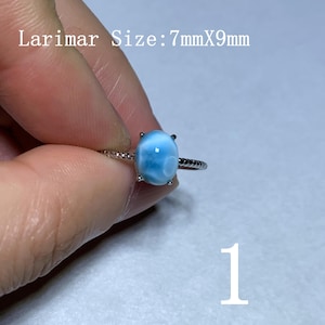 Könnte beinhalten: Ein Silberring mit einem ovalen, hellblauen Larimar-Edelstein. Der Stein misst 7 mm x 9 mm. Die Ringschiene hat ein strukturiertes, gedrehtes Seildesign. Die Zahl 1 ist in der unteren rechten Ecke des Bildes zu sehen.