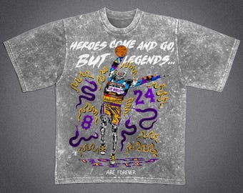 May include: A gray, acid-wash t-shirt featuring a basketball player graphic. The design includes the text "HEROES COME AND GO, BUT LEGENDS... ARE FOREVER" with the number 24 and the number 8. The graphic is in yellow, purple, and blue.