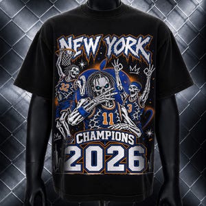 May include: A black t-shirt featuring a graphic print of three skeletons in basketball uniforms with the text NEW YORK, CHAMPIONS, and 2026. The skeletons are wearing jerseys numbered 32, 11, and 3, with blue and orange accents throughout the design.