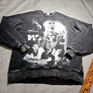 May include: Black and white sweatshirt with a distressed look featuring a collage of basketball players. The sweatshirt has the text "Westbrook" and "Why Not" printed on it.