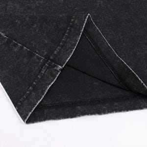 Pode incluir: Close-up da costura interna de uma pe&ccedil;a de roupa preta. O tecido tem um aspeto desgastado e vintage.