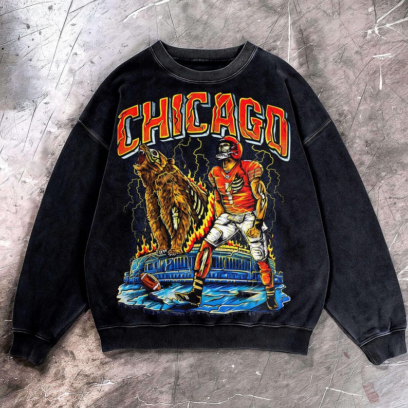 May include: Black crew neck sweatshirt with a distressed graphic. The design features a football player, a bear, and the word "CHICAGO" in orange and red. Includes lightning bolts and flames.