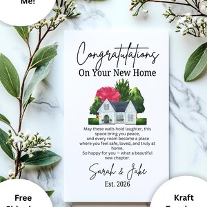 Op de afbeelding: Een witte wenskaart met de tekst "Congratulations On Your New Home" in een elegant lettertype. De kaart heeft een aquarel illustratie van een huis met een rode bloem en groene bomen. De namen "Sarah & Jake" en het jaar "Est. 2026" zijn ook opgenomen.