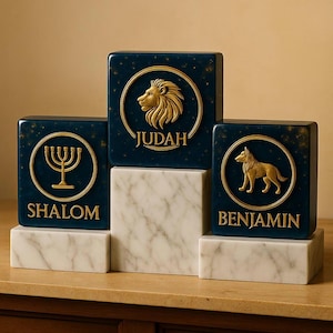 Può includere: Tre blocchi quadrati blu scuro con dettagli dorati e testo. Impilati su basi di marmo bianco. Il blocco superiore presenta un leone dorato e la parola "JUDAH". Il blocco di sinistra ha una menorah dorata e la parola "SHALOM". Il blocco di destra mostra un lupo dorato e la parola "BENJAMIN".