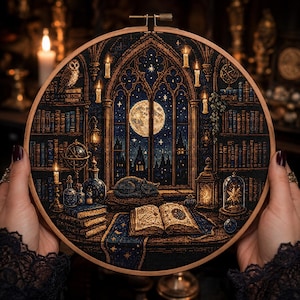 Puede incluir: Un bastidor de bordado circular con un diseño de punto de cruz que muestra el interior de una biblioteca de noche. La escena incluye una gran ventana arqueada con luna llena, estanterías, un libro abierto, un gato dormido y velas.