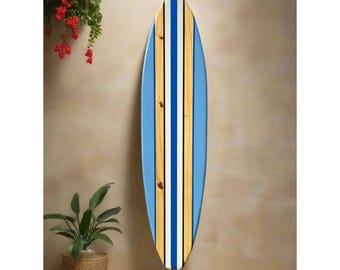 May include: A blue and white surfboard with brown wooden stripes. The surfboard is hanging on a wall.