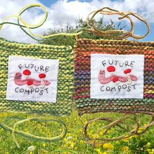 May include: Two knitted squares with embroidered images of worms and mushrooms. The squares are green and brown with yellow and orange stripes. The text on the squares reads "Future Compost".