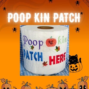 May include: A white toilet paper roll featuring embroidered text that reads Poop kin PATCH HERE in purple, blue, green, and red thread. The design includes a small orange pumpkin with a skull face and several colourful autumn leaves.