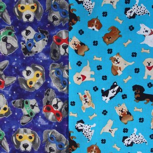 May include: Two fabric panels with dog-themed patterns. One features dog faces wearing colorful superhero masks on a dark blue background. The other has playful puppies, paw prints, and bones on a light blue background.