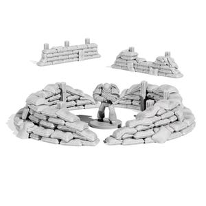 May include: A collection of miniature, light gray, sandbag fortifications and a soldier figurine. The set includes multiple sandbag walls and a soldier holding a rifle, all designed for tabletop gaming or model building.