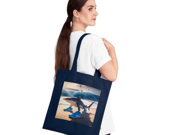 May include: A navy blue tote bag with a white canvas insert featuring a shark wearing blue trainers and walking on a beach.