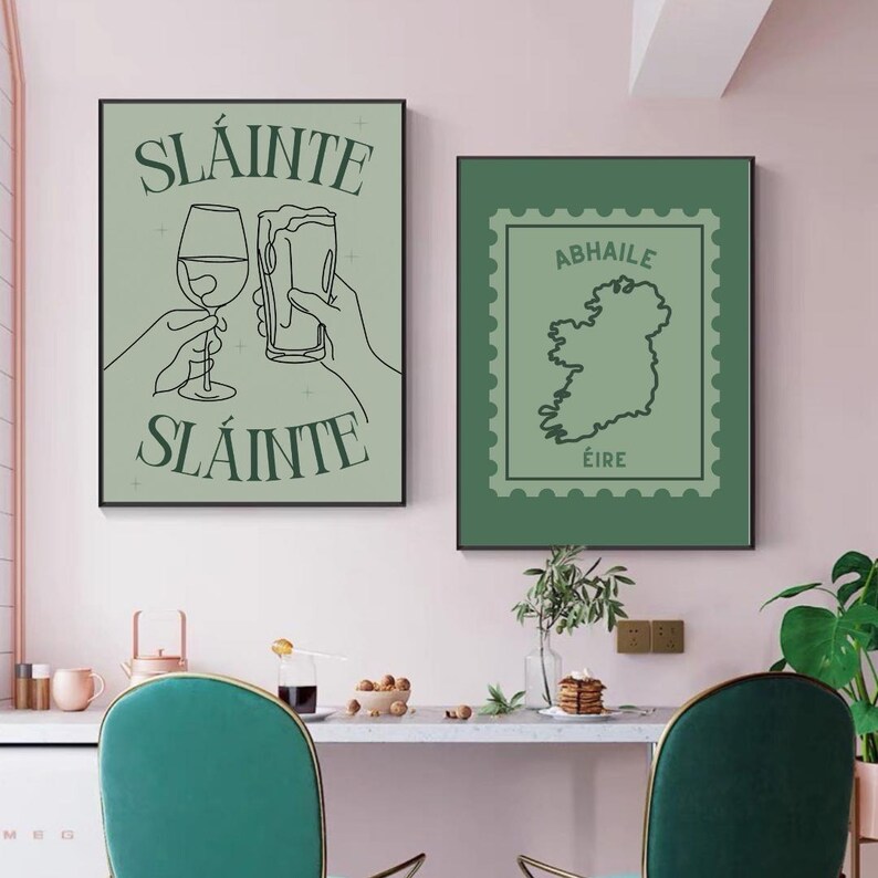 Peut inclure: Deux affiches encadr&eacute;es. L'affiche de gauche pr&eacute;sente le mot "Sl&aacute;inte" au-dessus et en dessous de dessins au trait d'un verre &agrave; vin et d'une chope de bi&egrave;re. L'affiche de droite montre une carte de l'Irlande dans un motif de timbre-poste, avec les mots "Abhaile" et "&Eacute;ire".