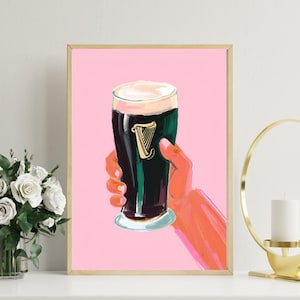 May include: A pink background with a glass of dark beer with a white head. The beer has a green and black design with a gold harp logo. The beer is in a hand with a pink and orange color. Guinness Pint Art Print Beer Feminine Stout in Pink - Digital Download, Modern Bar Decor, Cute Pub Wall Art, Irish Ireland Fun Art Guinness Pint Art Print Beer Feminine Stout in Pink - Digital Download, Modern Bar Decor, Cute Pub Wall Art, Irish Ireland Fun Art
