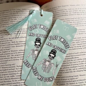 Peut inclure: Deux marque-pages bleu turquoise avec un squelette tenant une tasse de café. Les marque-pages présentent le texte "Plot Twists and Caffeine" et "Keep Me Going".