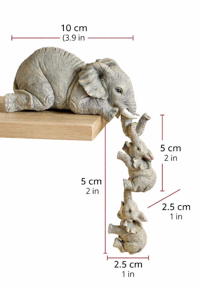 May include: A gray elephant figurine with three smaller elephants hanging below. The largest elephant is 10 cm (3.9 in) long, and the smaller elephants are 2.5 cm (1 in) wide and 5 cm (2 in) tall. The figurine is on a wooden shelf.