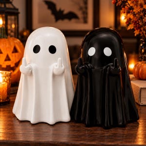 Può includere: Due statuette di fantasmi in ceramica, una bianca con occhi neri e una nera con occhi bianchi. Entrambi i fantasmi hanno teste arrotondate e corpi drappeggiati, ognuno dei quali alza entrambi i medi. Le figure hanno una finitura liscia e lucida.