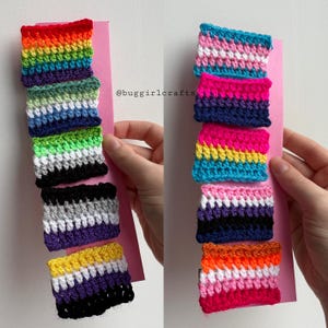 May include: A selection of crocheted pride flag patches, featuring rainbow, transgender, bisexual, and non-binary designs. The patches are presented on a pink card. The text "@buggirlcrafts" is visible.