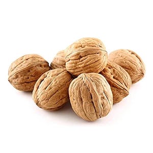 May include: A pile of whole walnuts with textured, light brown shells. The nuts are arranged in a slightly overlapping cluster against a white background, showcasing their natural, organic appearance. The image highlights the details of the nut's surface.