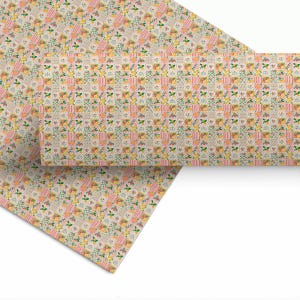 May include: A sheet of fabric or paper featuring a repeating grid pattern of small squares. The design alternates between pink and white vertical stripes, light green and white checkered squares, and floral motifs with yellow and orange flowers.
