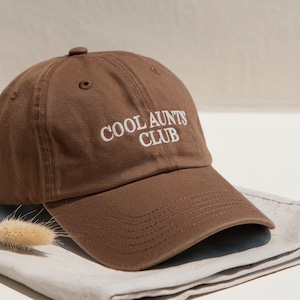 May include: A set of three ceramic mugs with a speckled, matte finish. The mugs are in shades of cream, light gray, and dark gray. Each mug has a simple, minimalist design and a rounded handle.