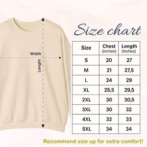 May include: A cream-colored sweatshirt with a size chart. The chart shows chest and length measurements in inches for sizes S through 5XL. The text "Recommend size up for extra comfort!" is at the bottom.