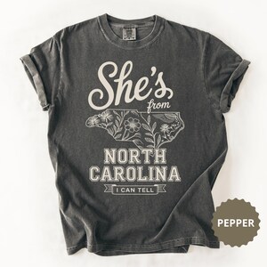 She's from North Carolina t-shirt with floral outline of the state.