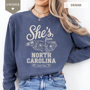 Crewneck sweatshirt with "She's from North Carolina" text and floral outline.