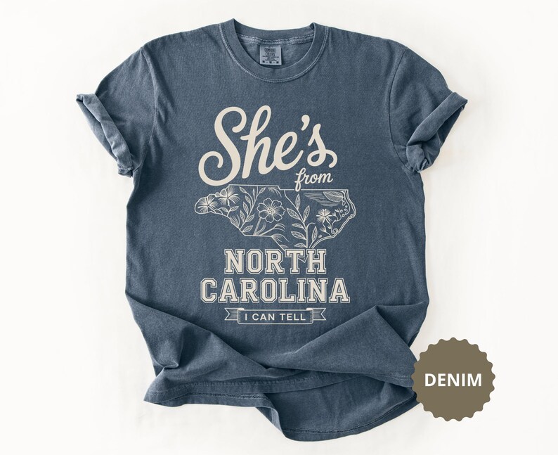 Navy t-shirt with "She's from North Carolina" and floral state outline.