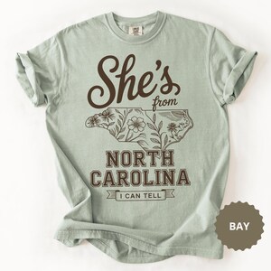 She's from North Carolina t-shirt with floral outline of the state.