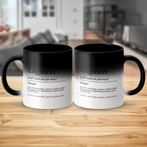 Mug with "Engineer" definition on black and white sides, some background blur.