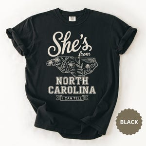 Black t-shirt with "She's from North Carolina" and floral map.