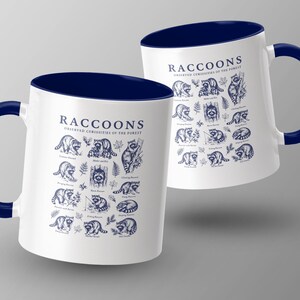 Two white mugs with navy handles feature a repeating dark blue raccoon illustration and text.