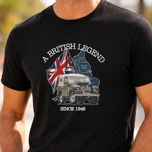 May include: Black t-shirt featuring the text "A BRITISH LEGEND SINCE 1948" with a graphic of a British flag and a vintage off-road vehicle. The person is wearing sunglasses and blue jeans.
