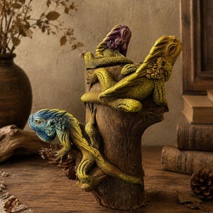 May include: A decorative sculpture featuring three textured lizards in blue, yellow, and purple perched on a brown tree stump. The lizards have detailed scales and distinct poses, with one climbing the side and two resting on the top surface.