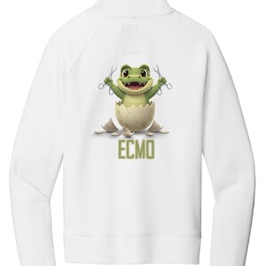 May include: White zip-up sweatshirt featuring a cartoon frog emerging from a cracked egg, holding scissors. The frog is green with a smiling face. The text "ECMO" is below the egg in green.