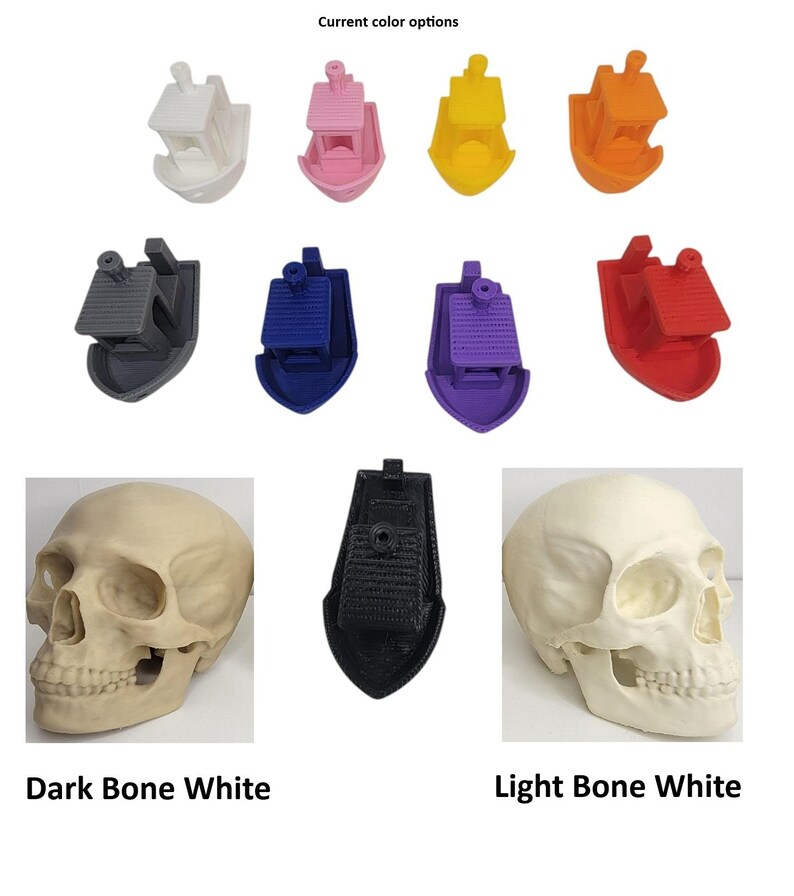 K&ouml;nnte beinhalten: Eine Auswahl an 3D-gedruckten Bootsmodellen in verschiedenen Farben, darunter Wei&szlig;, Rosa, Gelb, Orange, Grau, Blau, Lila und Rot. Das Bild zeigt auch zwei Sch&auml;delmodelle in dunklem und hellem Knochenwei&szlig; sowie ein schwarzes Bootsmodell.