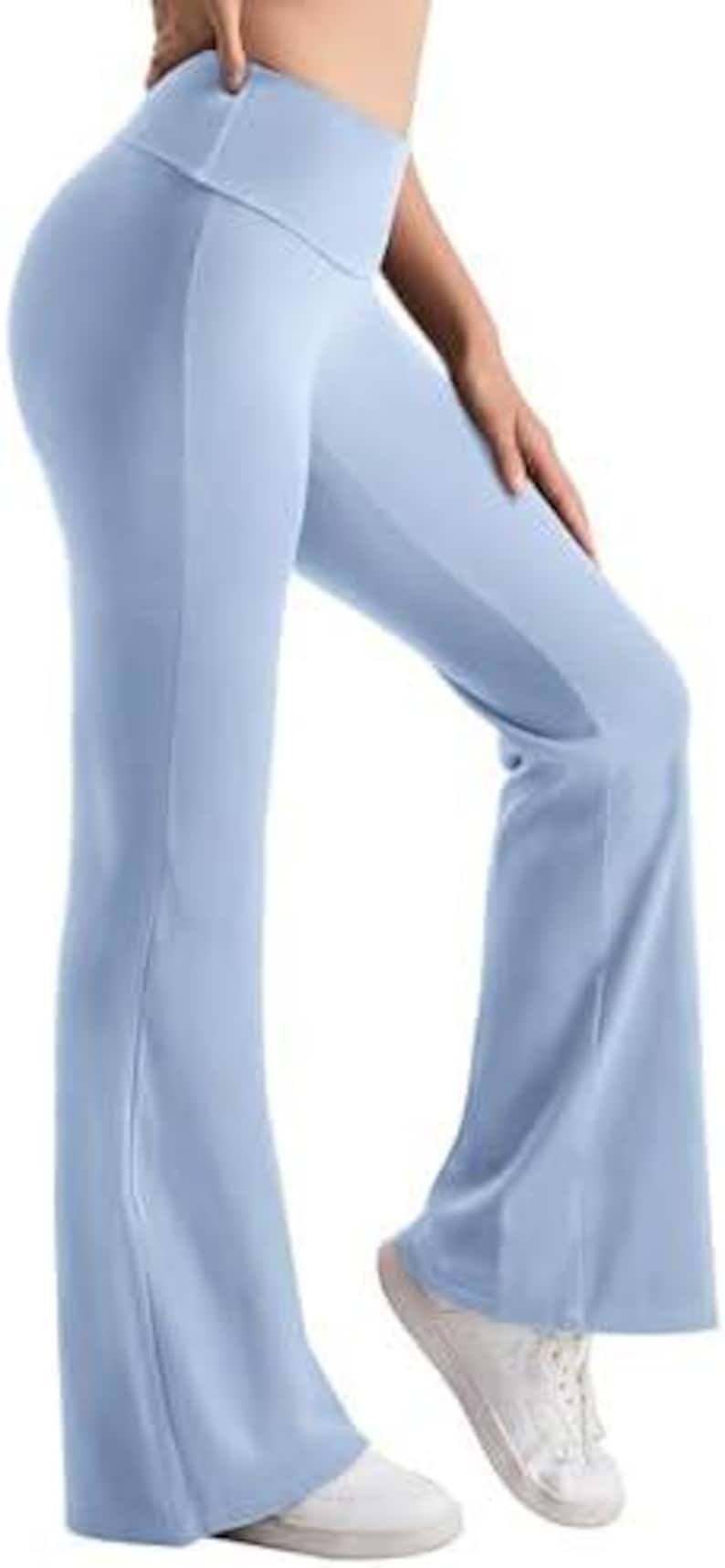Light blue yoga pants with a flared leg design. The pants have a high waistband and are made of a smooth, stretchy material. The pants are shown with white sneakers.