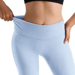 Light blue leggings with a wide, folded waistband. The leggings are made of a soft, stretchy material. A black crop top is also visible.