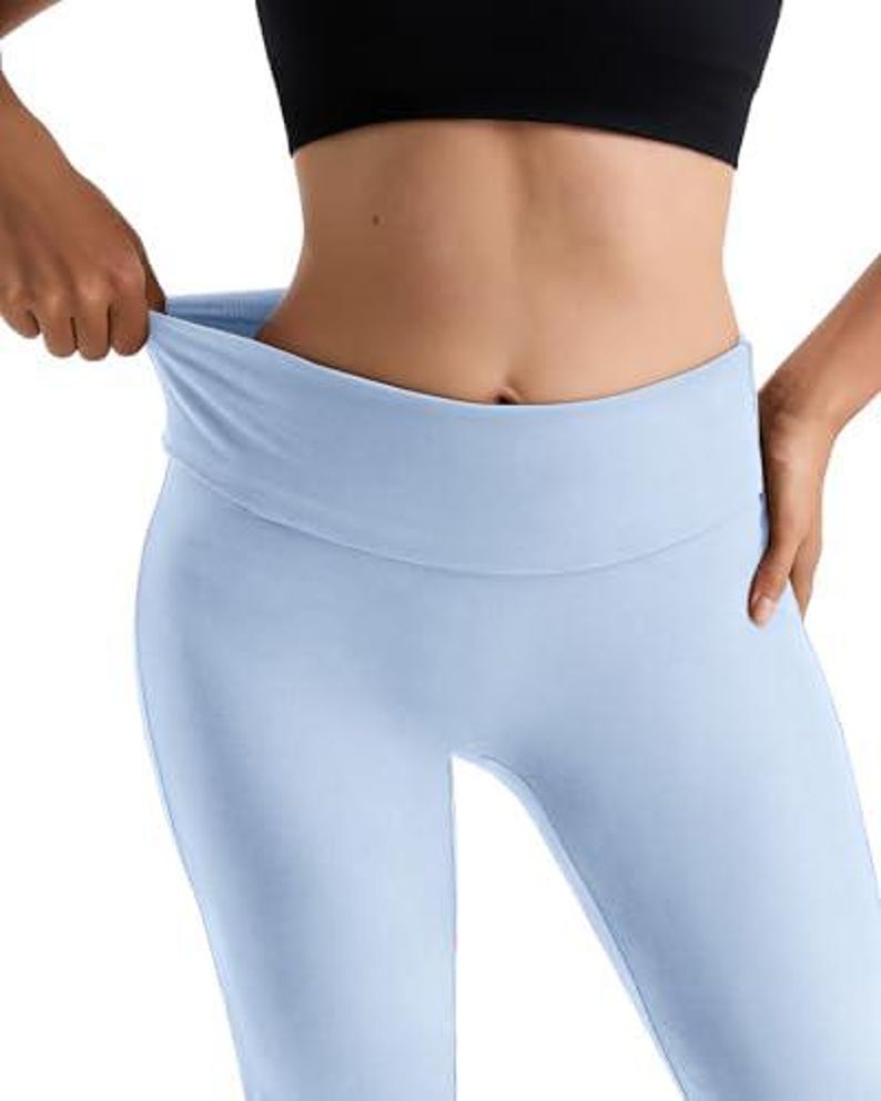 Light blue leggings with a wide, folded waistband. The leggings are made of a soft, stretchy material. A black crop top is also visible.