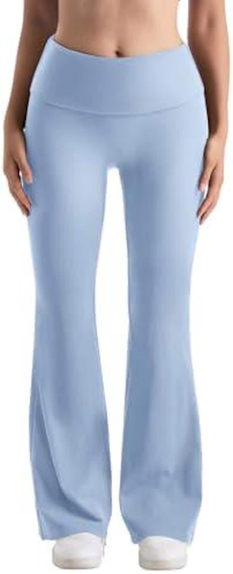 Light blue flared yoga pants with a high waistband. The pants are made of a soft, stretchy material and have a flared leg opening. The pants are shown with white sneakers.