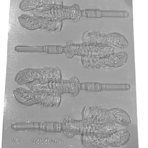 May include: A clear plastic mold for making four lobster-shaped lollipops. The mold has four cavities, each with a detailed lobster design and a stick holder. The mold is labeled "00241-03".