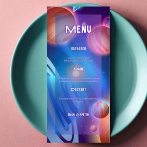 May include: A vertical menu card with a space-themed design, featuring planets in shades of orange, pink, and purple against a blue background. The menu includes sections for starter, main, and dessert, with the text "MENU" at the top and "BON APPETIT!" at the bottom. The card is placed on a teal plate.