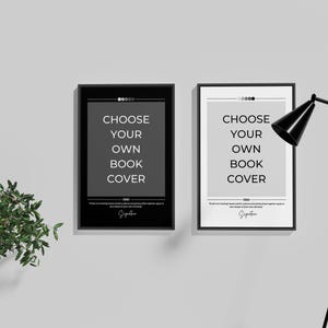 May include: Two black framed posters with white text that reads "Choose your own book cover" on a white wall. A black floor lamp is in the right corner of the image.