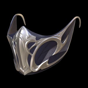 Puede incluir: Una máscara facial plateada y negra con diseños intrincados y estilizados. La máscara tiene una forma curva y está hecha de una combinación de metal y tela.