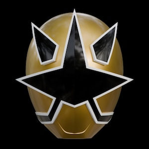 May include: A gold-colored mask with a black star-shaped design in the center. The mask has white and black accents around the star and eye openings. The mask is set against a black background.