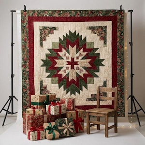 May include: A rectangular quilt featuring a central star pattern in shades of deep red, forest green, and cream, surrounded by a floral border. The quilt is displayed behind a stack of wrapped gift boxes and a wooden chair on a white floor.