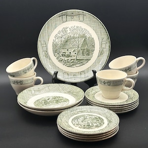 May include: A ceramic dinnerware set featuring a green and white transferware pattern of a water mill and rural landscape. The collection includes a large plate, several smaller plates, saucers, and cups, all decorated with a cross-hatched border.