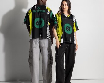 May include: Two people wearing matching black jerseys with the text "SIX SEVEN" and the number "67" in a green circle. The jerseys have yellow and white accents. One person wears gray cargo pants, and the other wears black cargo pants.