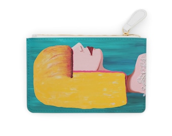 May include: A rectangular zipped pouch featuring a painted illustration of a person with blonde hair and a pink face resting against a large yellow block, set against a teal background. The pouch has a white zip pull at the top right corner.