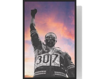 May include: Framed poster featuring a black and white statue of a person with a raised fist. The statue is set against a vibrant sunset sky. The number "3017" is visible on the statue's chest.